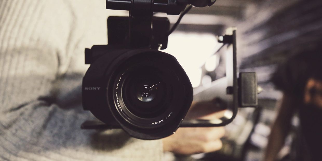 Close-up of a person holding a Sony video camera.