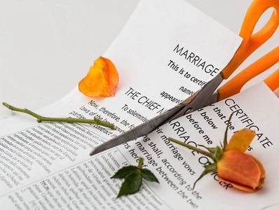 Picture of an angry spouse with pair of scissors cutting up the couple's marriage certificate.