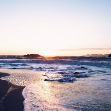 Sunset over the ocean waves at a serene beach.