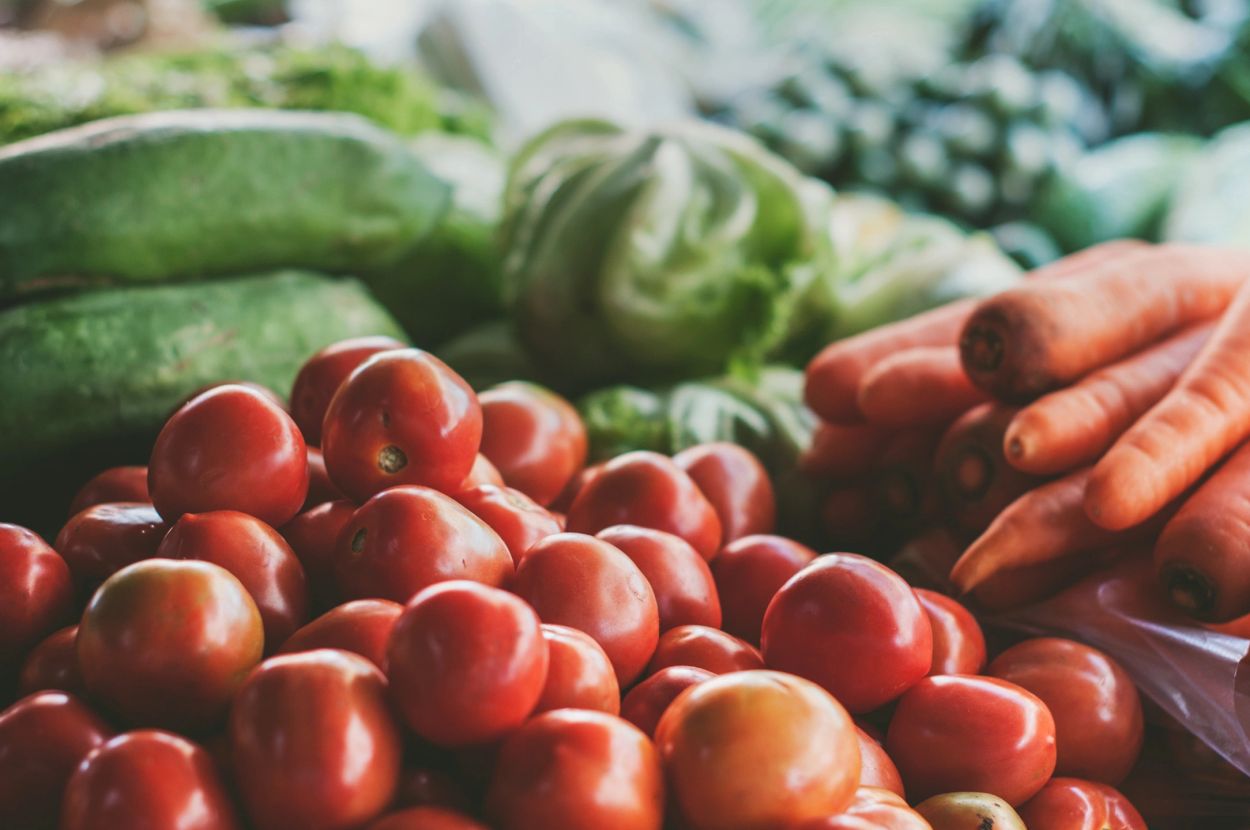 Fresh tomatoes, carrots, and green vegetables.
