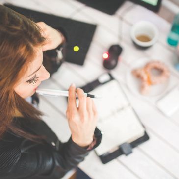 a female Virtual Executive Assistant holding a pen