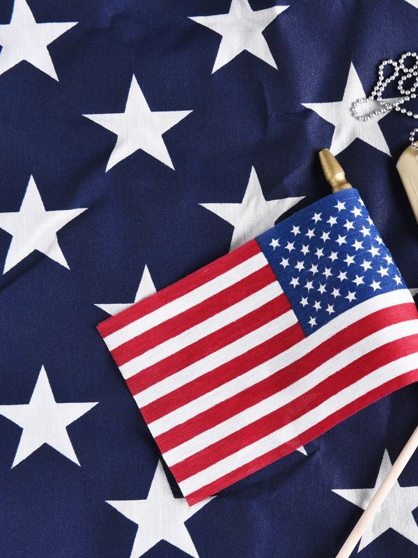 Small American flag on a larger star-patterned fabric background.