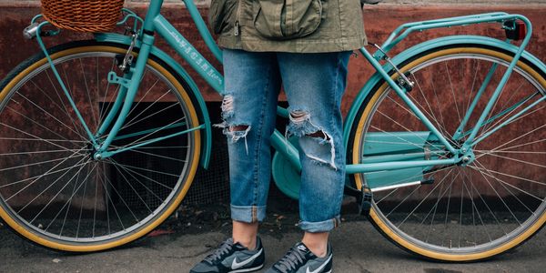 A person standing by their bike in the city