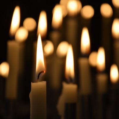 Close-up of lit candles in the dark.