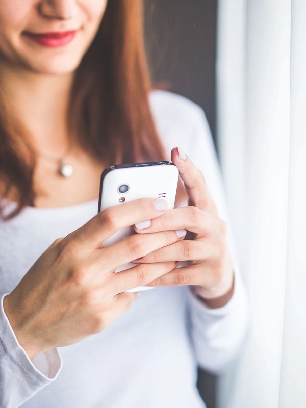 A patient sitting in a bright D.C. coffee shop or apartment, booking an appointment on their phone.