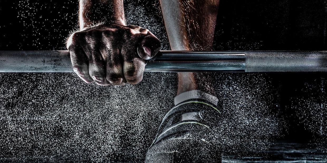 a man grabbing a barbell