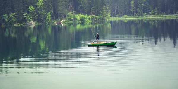 Stock photo of an angler in a lake on a kayak.