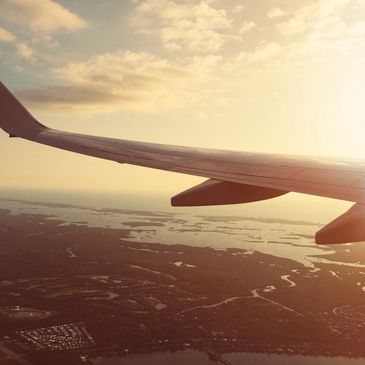 photo of an airplane wing flying over the coast