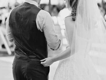 Groom and bride facing guests in black and white photo.