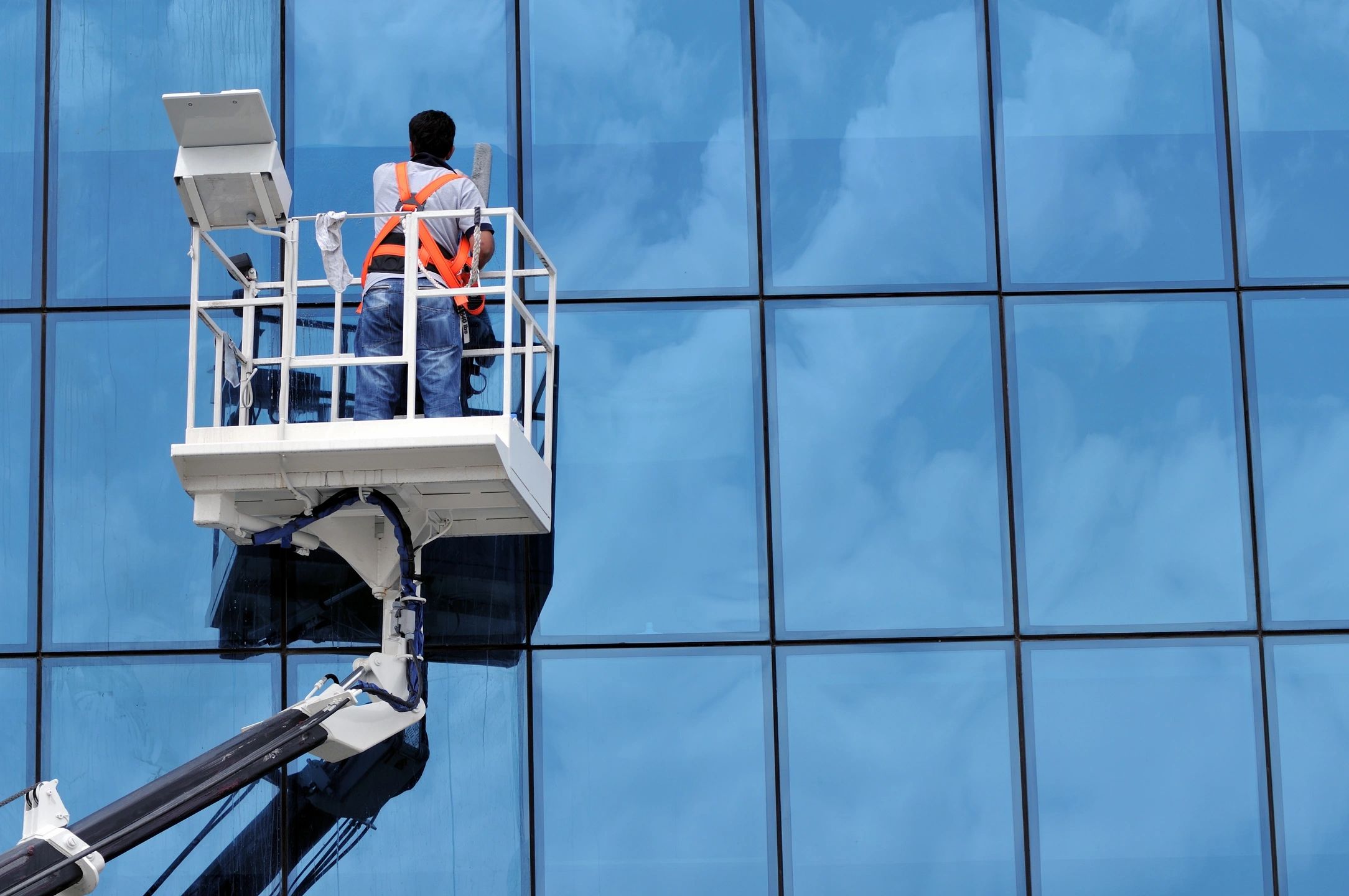 Person cleaning the outside window of a building