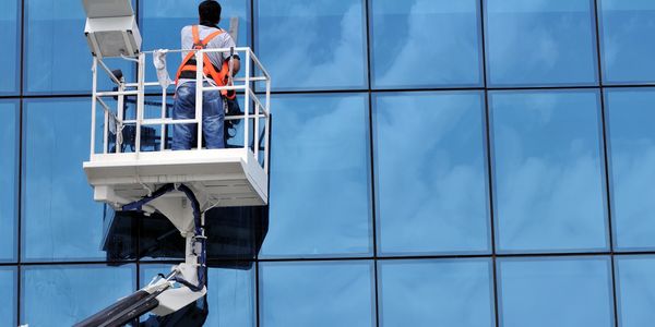 Cleaning office building windows from a cherry picker.