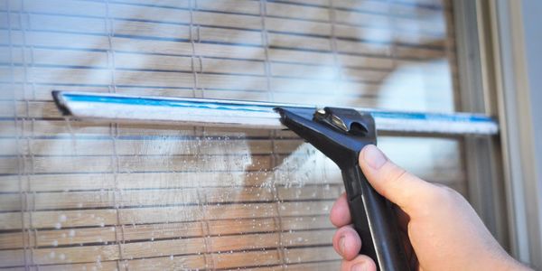 technician cleaning a soapy clean window