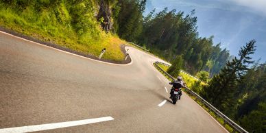 Motorcyclists riding on a winding mountain road.