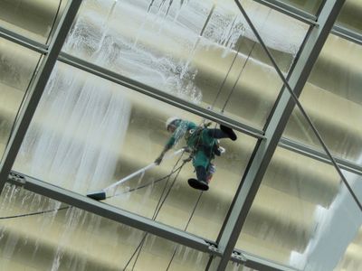 Window cleaning picture from below showing soap and scrubbing by a worker