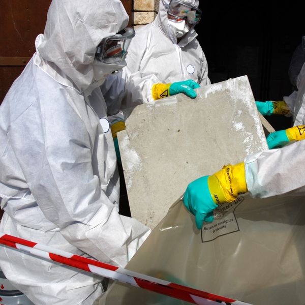 men in hazmat suits removing waste for a general construction contractor