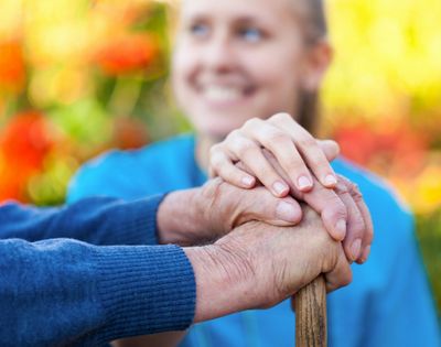 A woman compassionately holding a mans hand to help him