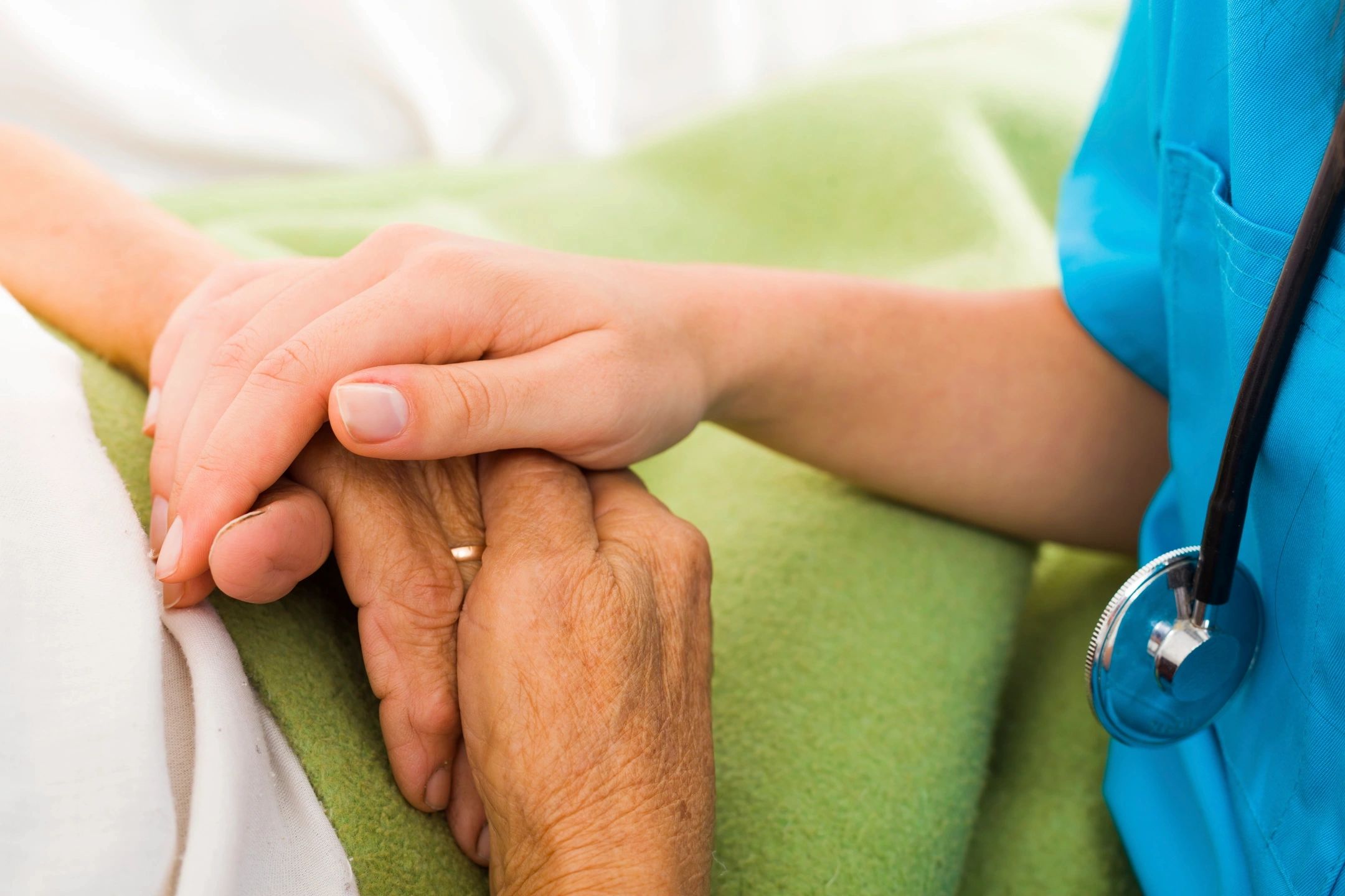 A medical professional holding the elder’s hands