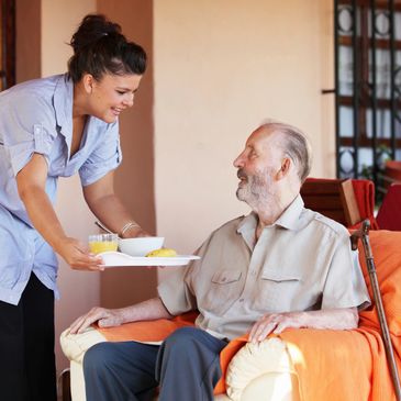 A nurse is serving food to the patient 