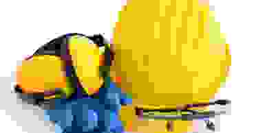 Yellow and black earmuffs, blue rubber gloves, yellow hardhat and safety glasses.