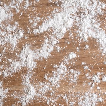 White powder scattered on a wooden surface.