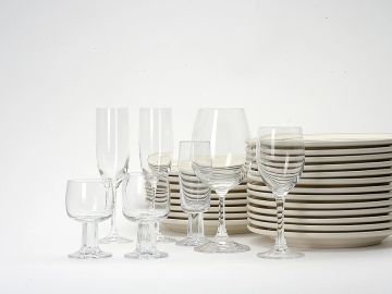 Variety of glassware with stacked white plates.