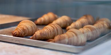 Freshly baked croissants on a baking tray.
