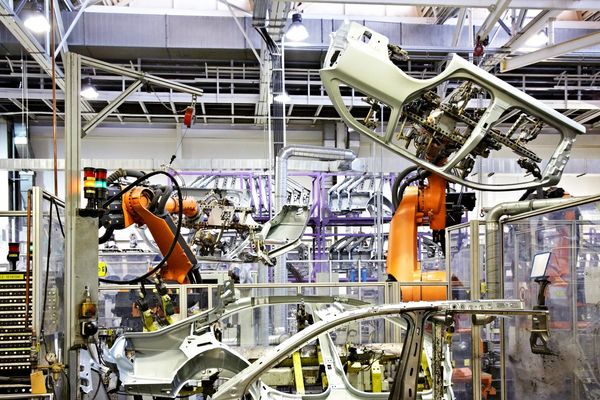 Robotic arms assembling car doors in a factory.