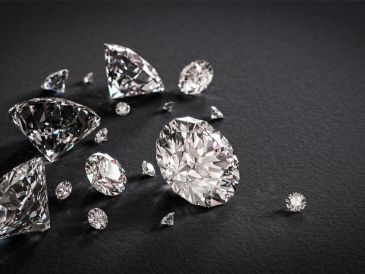 Scattered clear diamonds on a dark surface.