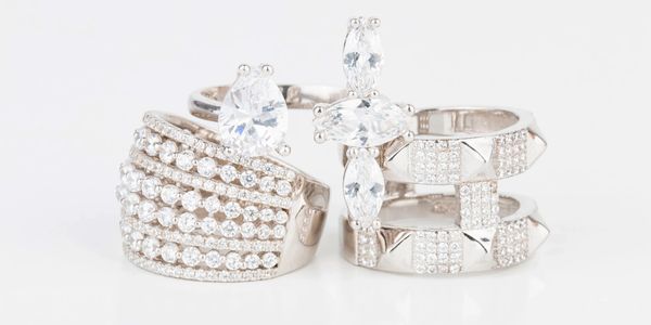 Two sparkling silver rings adorned with clear gemstones on a white background.