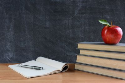 A Stack of Books, an Apple, A Pen, and a Notebook