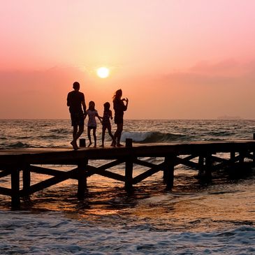 Family  walking on the beach with sunset