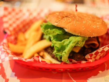 Close-up of a lettuce burger with fries in a red basket.