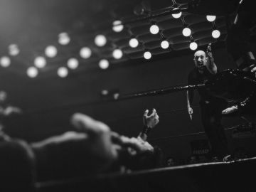 Wrestler lying on the mat, referee counting.