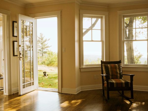 A cozy room with an open door and a dog outside.
