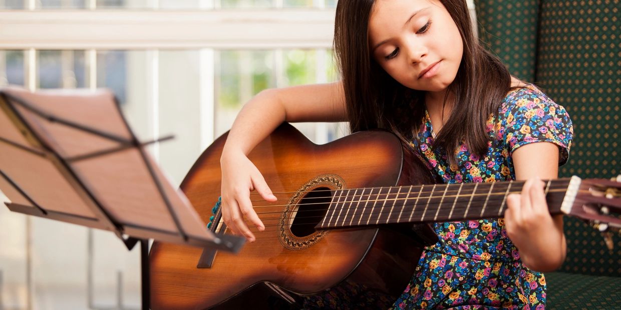 Little girl playing the acoustic guitar