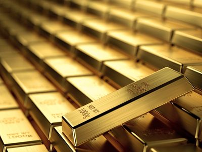 Stack of shiny gold bars with one prominently displayed.