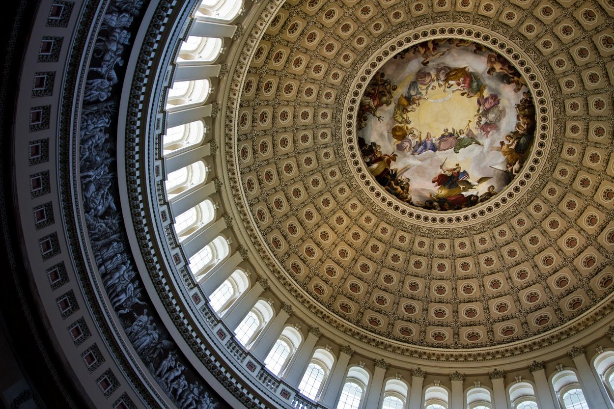 Ornate dome ceiling with intricate artwork and windows.