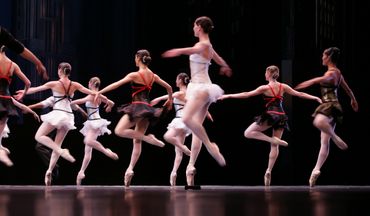 Ballet dancers performing on stage in tutus.