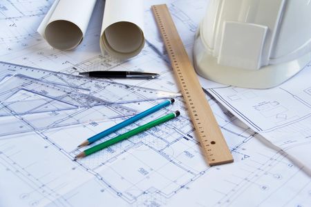 Architectural tools and sketches on a white desk.