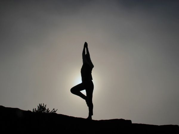 Silhouette of person doing yoga at sunset.