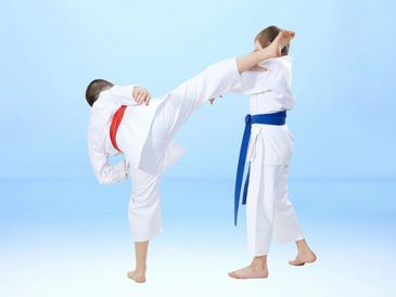 Two kids practicing karate with high kick.