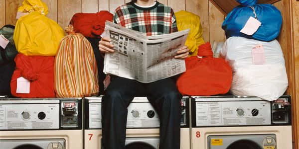 Photo of a guest reading the paper waiting for their laundry. 