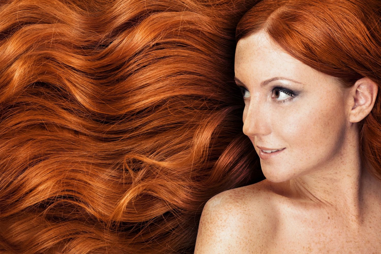 Woman with long red hair and sculpted eyebrows