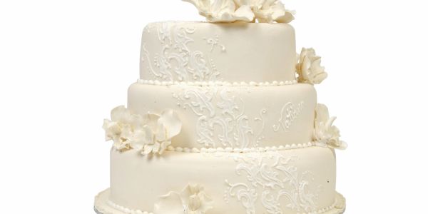 Elegant white three-tier wedding cake with floral decorations.
