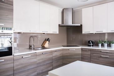 Modern kitchen with white and wood cabinets, a sleek sink, and stainless steel appliances.