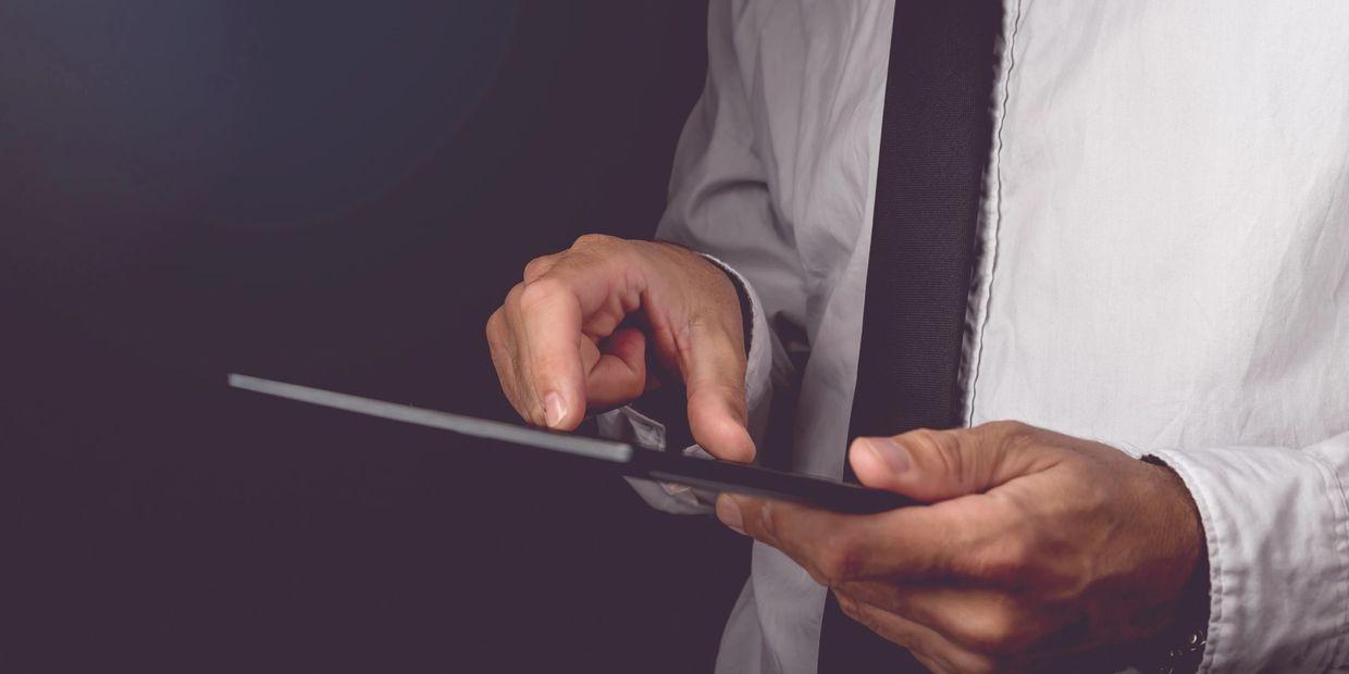 Closeup of businessman working on a tablet.