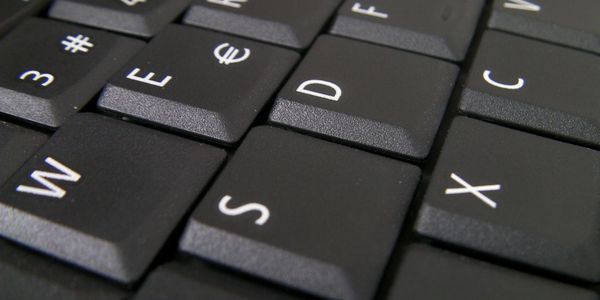 Close-up of a black keyboard showing keys W, E, S, D, X, C, and D.