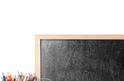 School supplies with a blank chalkboard and alarm clock.