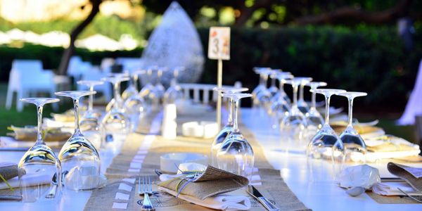 Elegantly set outdoor dining table with upside-down wine glasses and napkins.