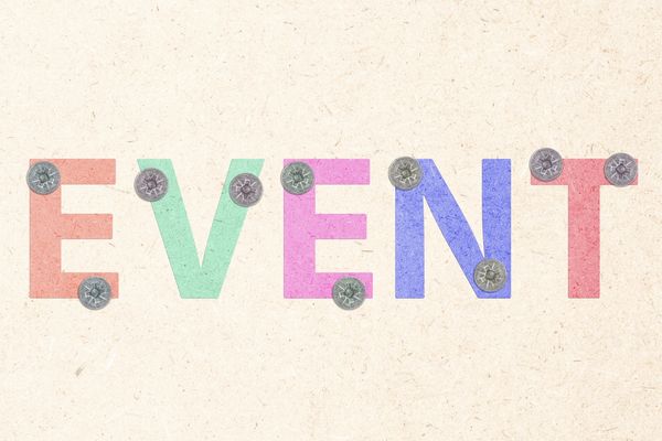 Colorful letters spelling EVENT pinned on a textured board.